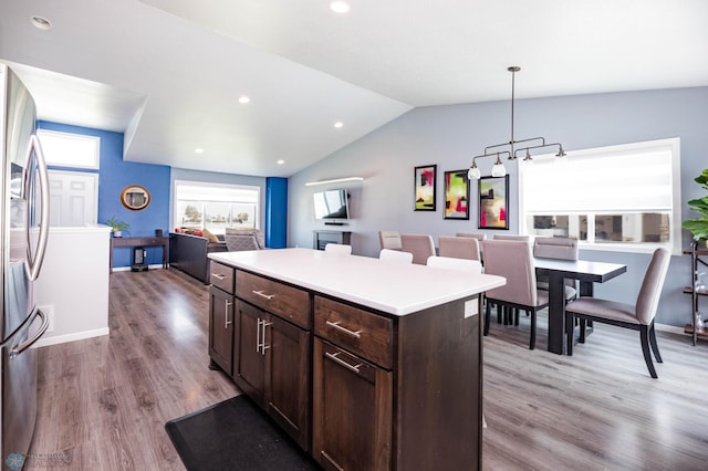 4701 11th St W, West Fargo, ND 58078 - kitchen featuring stainless steel fridge, dark brown cabinetry, wood finished floors, open floor plan, and a kitchen island
