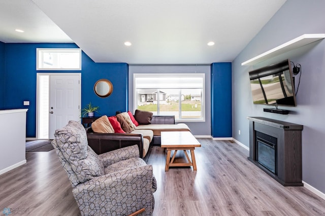 4701 11th St W, West Fargo, ND 58078 - living room with a glass covered fireplace, light wood finished floors, vaulted ceiling, and recessed lighting