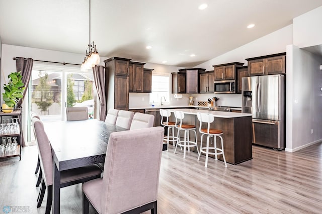 4701 11th St W, West Fargo, ND 58078 - dining space with vaulted ceiling, light wood-style flooring, and recessed lighting