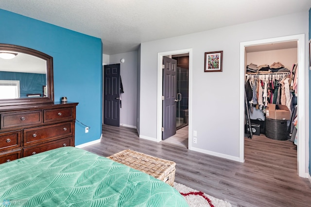 4701 11th St W, West Fargo, ND 58078 - bedroom featuring a spacious closet, wood finished floors, a closet, and ensuite bathroom