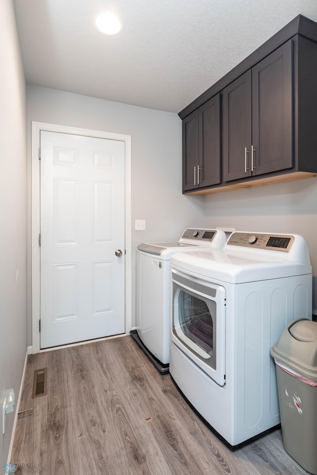 4701 11th St W, West Fargo, ND 58078 - laundry room with separate washer and dryer, cabinet space, and light wood finished floors