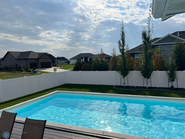 4701 11th St W, West Fargo, ND 58078 - view of pool featuring a fenced backyard and a residential view