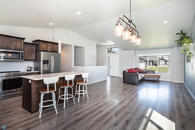 4701 11th St W, West Fargo, ND 58078 - kitchen with appliances with stainless steel finishes, lofted ceiling, a center island, a kitchen bar, and dark brown cabinetry