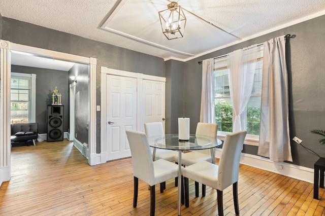 3114 Russell Ave N, Minneapolis, MN 55411 - dining area with light wood finished floors, a textured ceiling, and a chandelier
