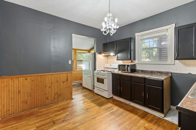 3114 Russell Ave N, Minneapolis, MN 55411 - kitchen with white appliances, under cabinet range hood, a chandelier, light wood-style flooring, and wainscoting