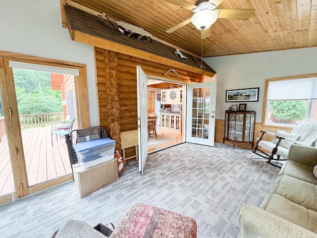34002 Fiske View Dr, Underwood, MN 56586 - living area with log walls, wooden ceiling, plenty of natural light, a ceiling fan, and a wainscoted wall
