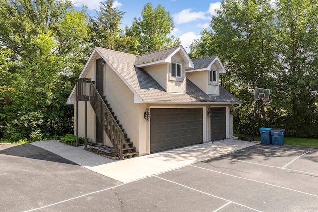 22620 Hayward Ave N, Forest Lake, MN 55025 - view of front of property featuring stucco siding, driveway, an attached garage, stairs, and roof with shingles