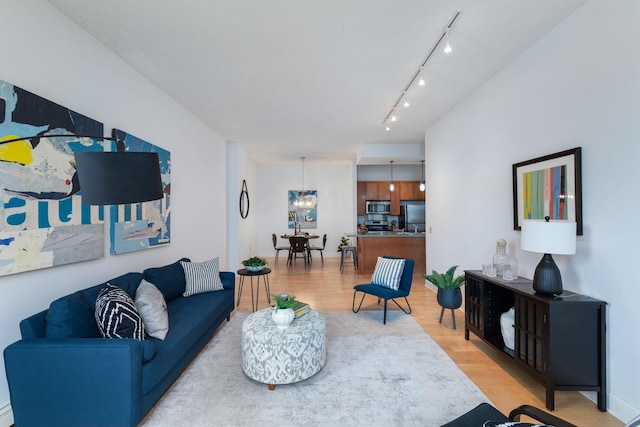 215 7th St NE Unit 205, Minneapolis, MN 55413 - living area with light wood-style floors, track lighting, and a chandelier