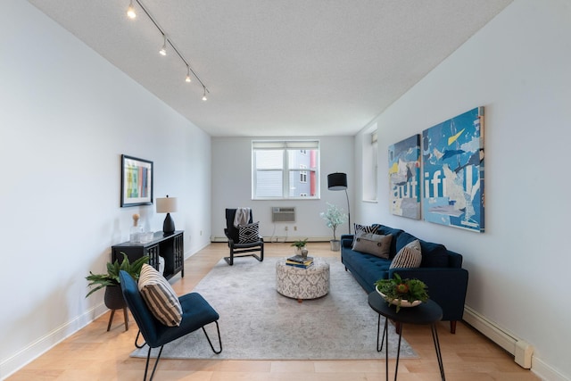 215 7th St NE Unit 205, Minneapolis, MN 55413 - living area featuring a baseboard radiator, light wood-type flooring, a wall mounted air conditioner, and track lighting