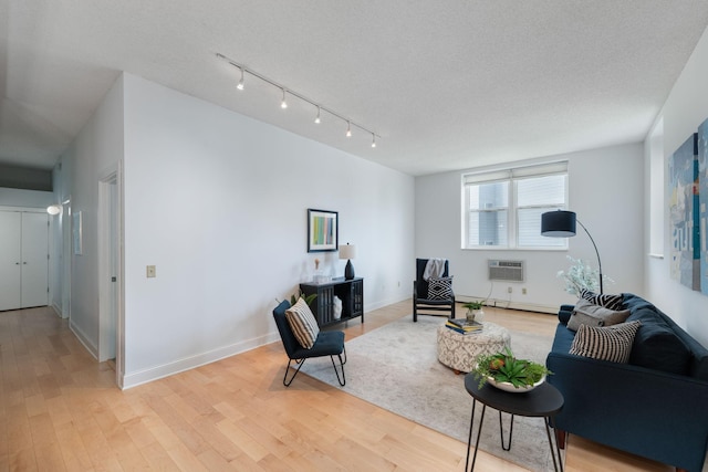 215 7th St NE Unit 205, Minneapolis, MN 55413 - living room featuring a wall mounted AC, light wood-style flooring, a baseboard radiator, and track lighting