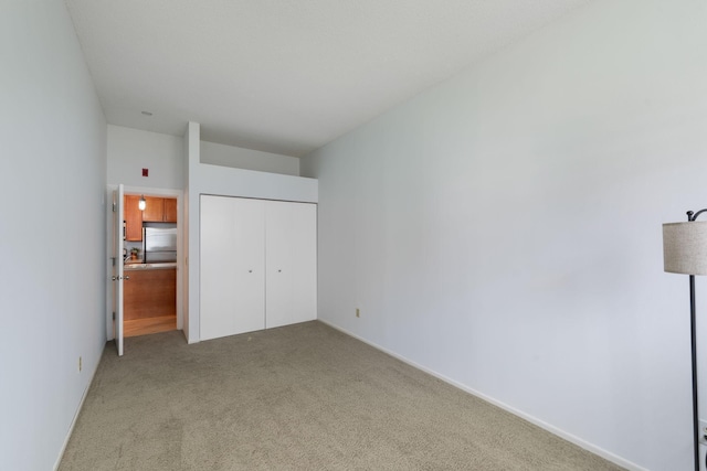 215 7th St NE Unit 205, Minneapolis, MN 55413 - unfurnished bedroom featuring stainless steel refrigerator, light colored carpet, and a closet