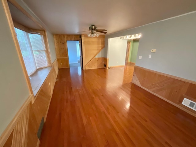 108 Johnson St NE, Brownsdale, MN 55918 - unfurnished room with wood finished floors, wood walls, a ceiling fan, and wainscoting