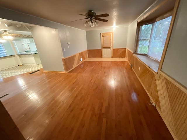 108 Johnson St NE, Brownsdale, MN 55918 - empty room with a ceiling fan, wood finished floors, a wainscoted wall, and wooden walls
