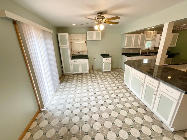 108 Johnson St NE, Brownsdale, MN 55918 - kitchen featuring dark countertops, ceiling fan, light floors, and white cabinets