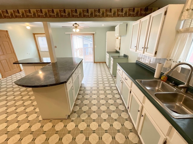 108 Johnson St NE, Brownsdale, MN 55918 - kitchen featuring dark countertops, a center island, light flooring, and white cabinets