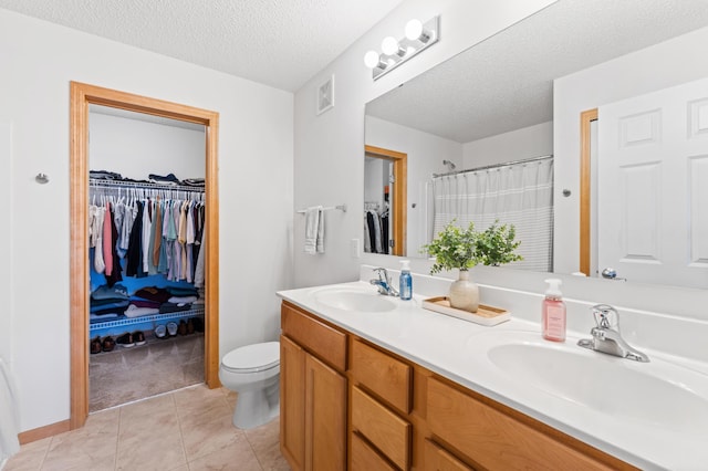 15588 Early Bird Cir Unit 1704, Apple Valley, MN 55124 - full bathroom featuring double vanity, a spacious closet, a textured ceiling, tile patterned flooring, and curtained shower