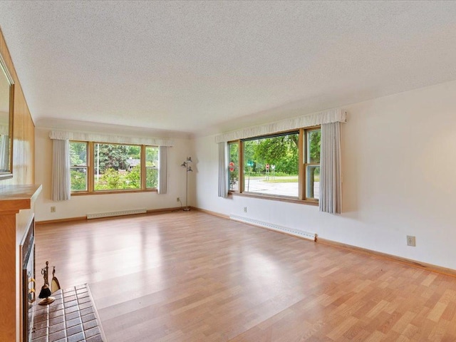 517 Cedar St, Brainerd, MN 56401 - unfurnished living room with a baseboard radiator, light wood-style flooring, and a textured ceiling