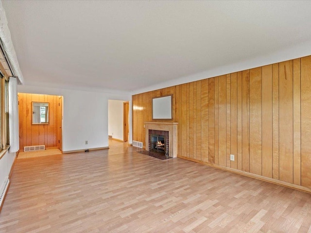 517 Cedar St, Brainerd, MN 56401 - unfurnished living room featuring wood finished floors, wooden walls, and a fireplace with flush hearth