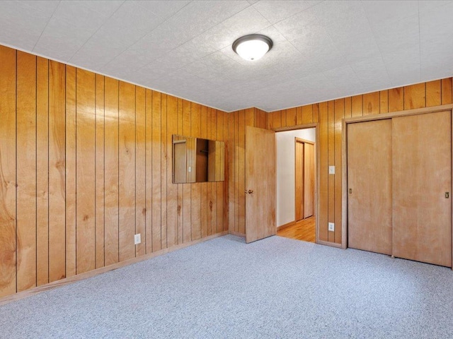 517 Cedar St, Brainerd, MN 56401 - unfurnished bedroom featuring wooden walls, carpet floors, and a closet