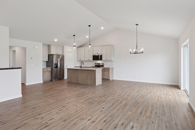 1096 Prospect Pointe Rd, Jordan, MN 55352 - kitchen featuring appliances with stainless steel finishes, open floor plan, a chandelier, a kitchen island with sink, and decorative backsplash