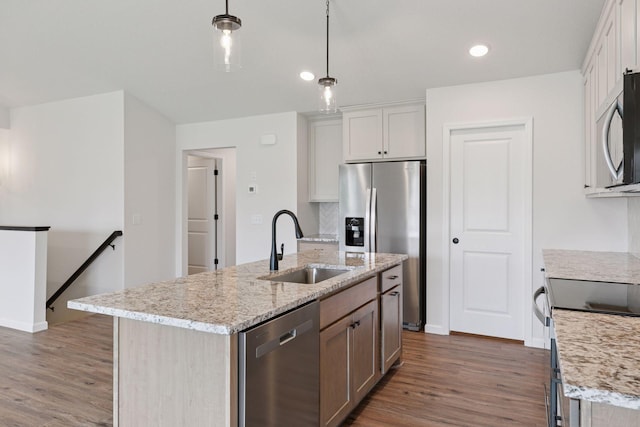 1096 Prospect Pointe Rd, Jordan, MN 55352 - kitchen featuring appliances with stainless steel finishes, wood finished floors, a kitchen island with sink, backsplash, and light stone counters