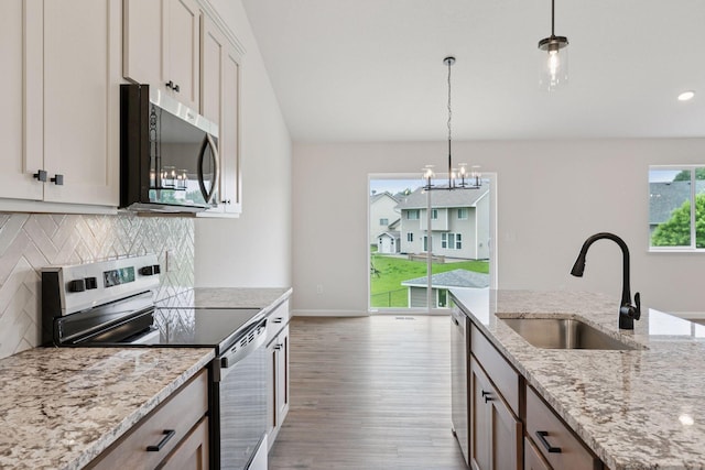 1096 Prospect Pointe Rd, Jordan, MN 55352 - kitchen featuring appliances with stainless steel finishes, wood finished floors, decorative backsplash, pendant lighting, and a chandelier