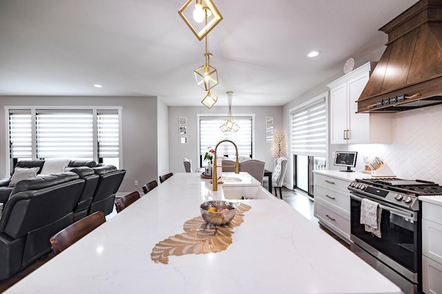 1205 Skyview Cir NW, Rochester, MN 55901 - kitchen with stainless steel range with gas stovetop, custom exhaust hood, tasteful backsplash, recessed lighting, and pendant lighting