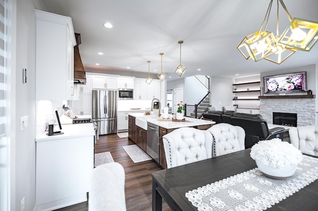 1205 Skyview Cir NW, Rochester, MN 55901 - dining area featuring stairs, recessed lighting, dark wood-style flooring, a stone fireplace, and a chandelier