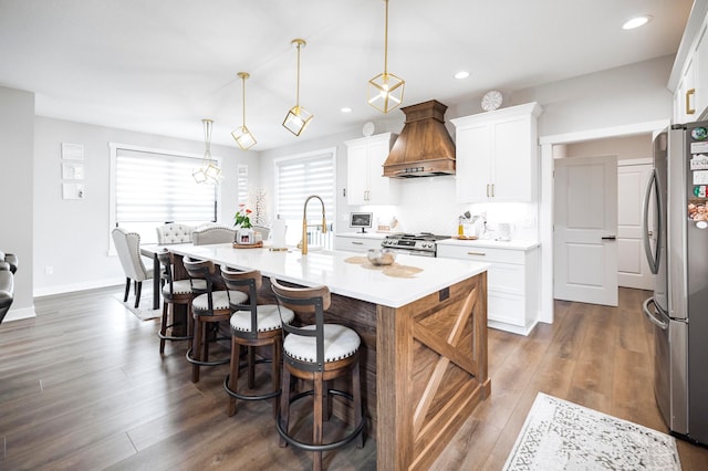 1205 Skyview Cir NW, Rochester, MN 55901 - kitchen with appliances with stainless steel finishes, premium range hood, a kitchen bar, dark wood finished floors, and recessed lighting