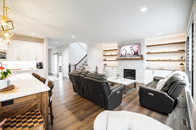 1205 Skyview Cir NW, Rochester, MN 55901 - living room featuring a barn door, dark wood-style floors, a stone fireplace, recessed lighting, and stairs