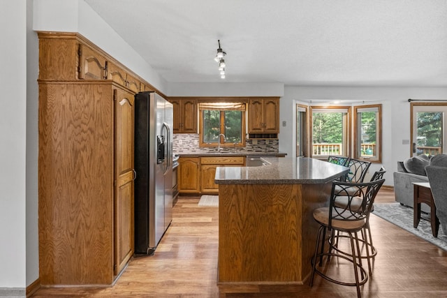 13790 Crane St NW, Andover, MN 55304 - kitchen with a center island, stainless steel appliances, brown cabinets, light wood-style floors, and backsplash