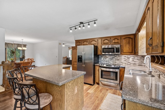 13790 Crane St NW, Andover, MN 55304 - kitchen with appliances with stainless steel finishes, light wood-style flooring, a kitchen bar, and a center island