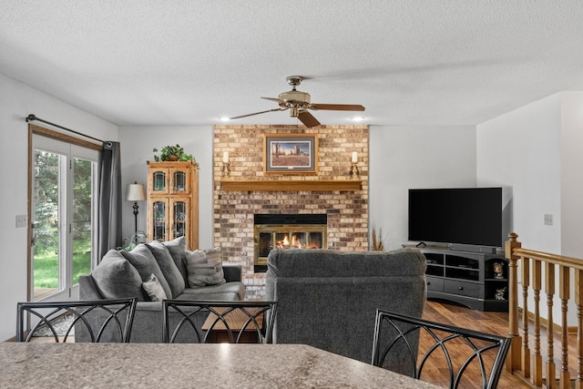 13790 Crane St NW, Andover, MN 55304 - living area featuring a ceiling fan, a textured ceiling, wood finished floors, and a brick fireplace
