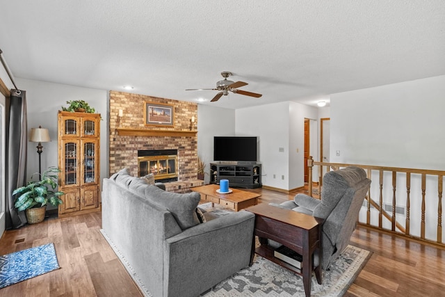 13790 Crane St NW, Andover, MN 55304 - living area featuring ceiling fan, light wood-style flooring, a textured ceiling, and a brick fireplace