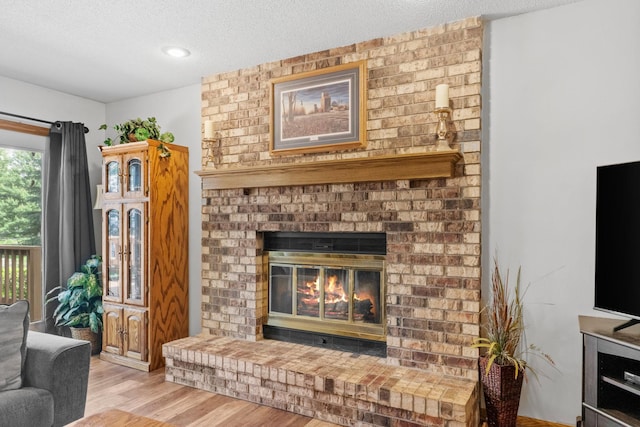 13790 Crane St NW, Andover, MN 55304 - living room featuring a textured ceiling, a fireplace, and wood finished floors