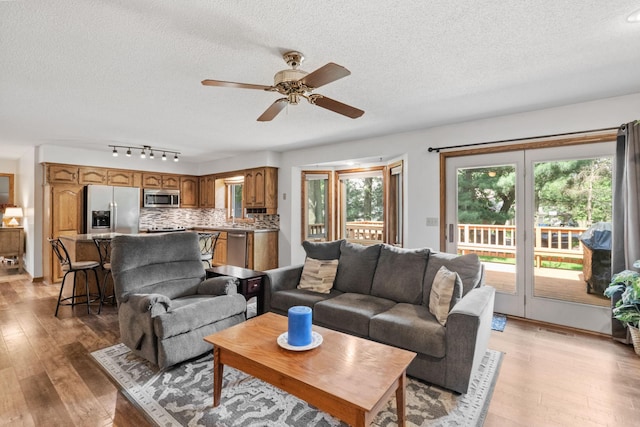 13790 Crane St NW, Andover, MN 55304 - living room with a textured ceiling, ceiling fan, and light wood-style flooring