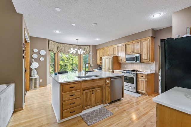 13845 Essex Trl, Apple Valley, MN 55124 - kitchen featuring appliances with stainless steel finishes, a textured ceiling, light countertops, light wood-style floors, and backsplash