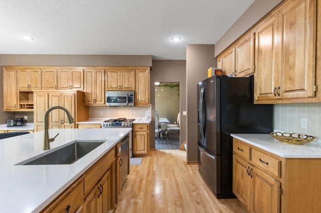 13845 Essex Trl, Apple Valley, MN 55124 - kitchen featuring appliances with stainless steel finishes, light countertops, backsplash, a textured ceiling, and light wood-style floors