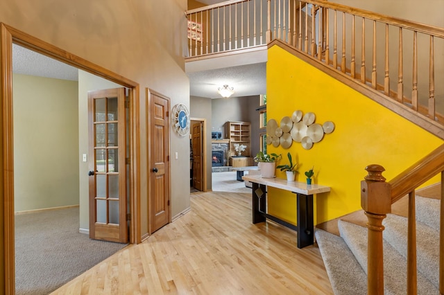 13845 Essex Trl, Apple Valley, MN 55124 - hallway with stairs, wood finished floors, a towering ceiling, and carpet flooring
