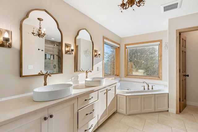 13845 Essex Trl, Apple Valley, MN 55124 - bathroom with a chandelier, a shower stall, a whirlpool tub, double vanity, and tile patterned flooring
