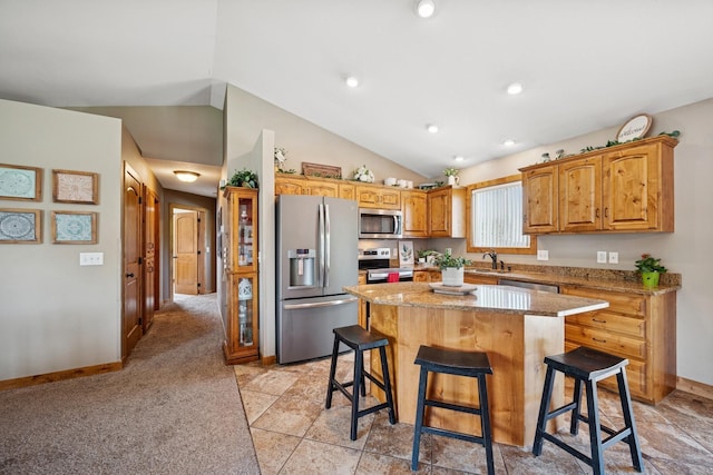 853 Texas Ct NW, Hutchinson, MN 55350 - kitchen with appliances with stainless steel finishes, vaulted ceiling, a kitchen breakfast bar, a kitchen island, and light stone countertops