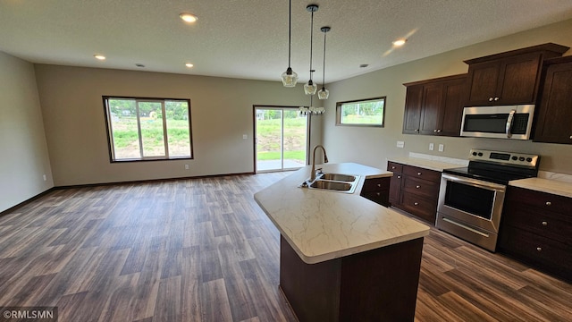 3104 Zuni St, Anoka, MN 55303 - kitchen with stainless steel appliances, light countertops, dark wood-type flooring, dark brown cabinetry, and an island with sink