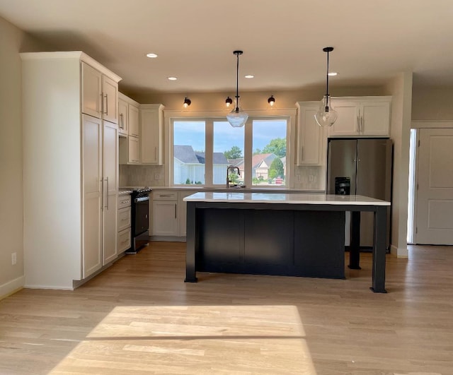 1945 Spruce Meadows Dr SE, Rochester, MN 55904 - kitchen with stainless steel fridge, gas range, a kitchen island, tasteful backsplash, and light wood finished floors