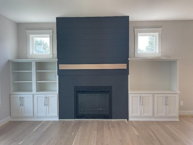 1945 Spruce Meadows Dr SE, Rochester, MN 55904 - unfurnished living room featuring light wood-style floors, healthy amount of natural light, and a large fireplace