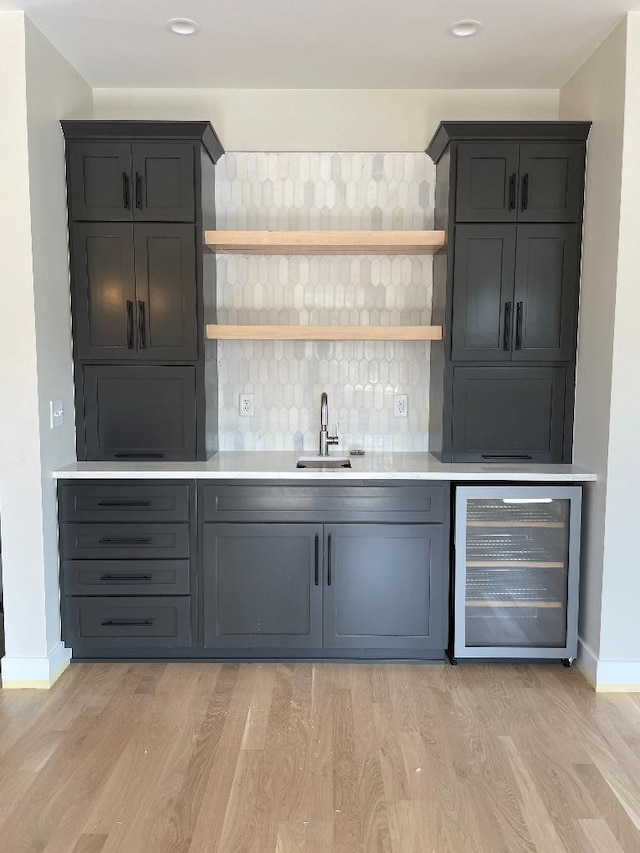 1945 Spruce Meadows Dr SE, Rochester, MN 55904 - bar featuring wine cooler, light wood-type flooring, and backsplash