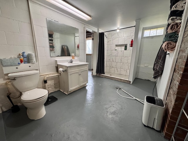 420 7th St, Marshall, MN 56258 - bathroom featuring finished concrete flooring, vanity, a tile shower, and concrete block wall