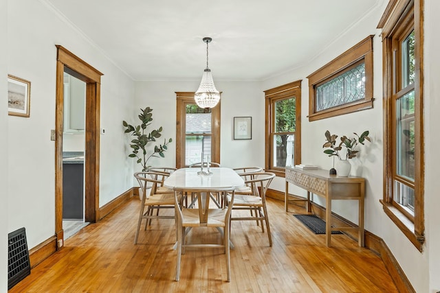 1112 29th Ave NE, Minneapolis, MN 55418 - dining area featuring light wood-style floors, a chandelier, and crown molding