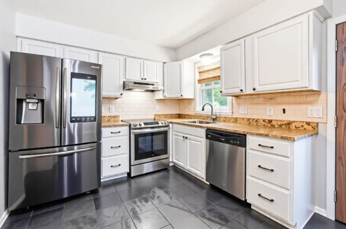 8400 Northern Dr, Crystal, MN 55427 - kitchen featuring appliances with stainless steel finishes, under cabinet range hood, white cabinets, and decorative backsplash