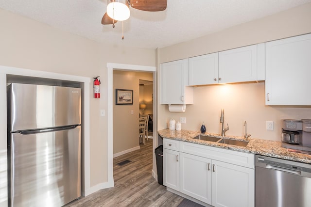 116 3rd Ave, Crosby, MN 56441 - kitchen featuring appliances with stainless steel finishes, a ceiling fan, white cabinets, light wood finished floors, and light stone countertops