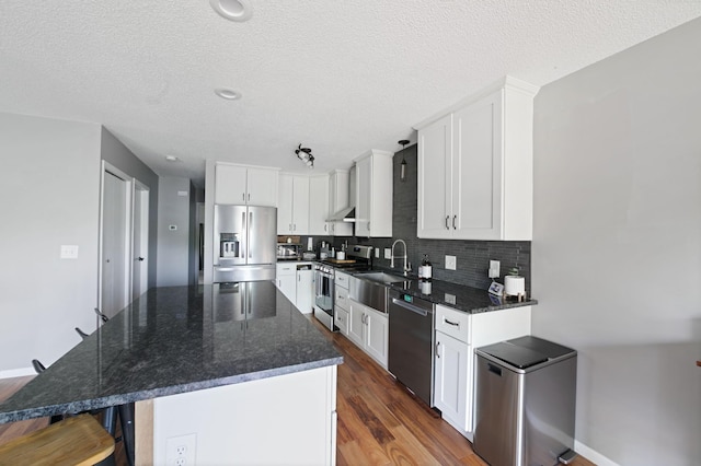 3576 Avon Ct, Woodbury, MN 55125 - kitchen with stainless steel appliances, white cabinetry, a center island, backsplash, and dark wood-style floors